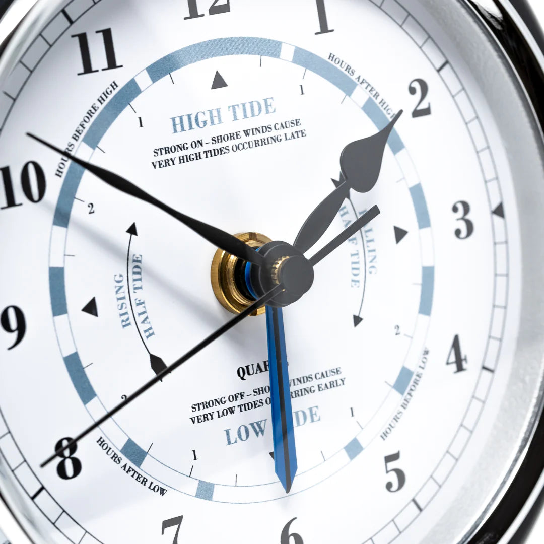 Close-up of an analog tide clock displaying high and low tide times, nautical instrument.