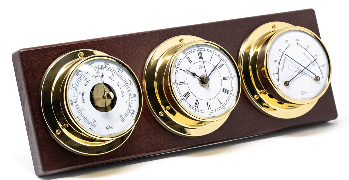 German made barometer, clock, and hygrometer set in gold on wooden mount