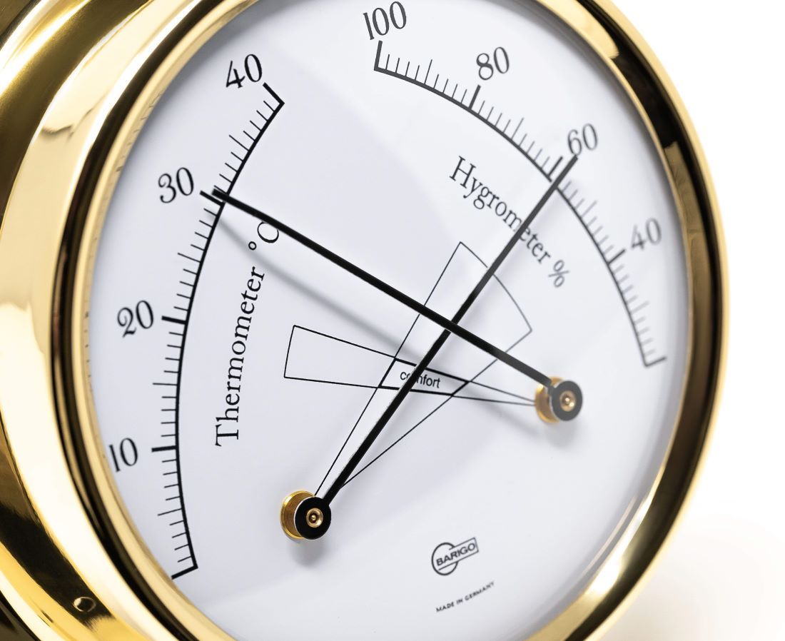 Gold framed German made analog thermometer and hygrometer weather instrument close up
