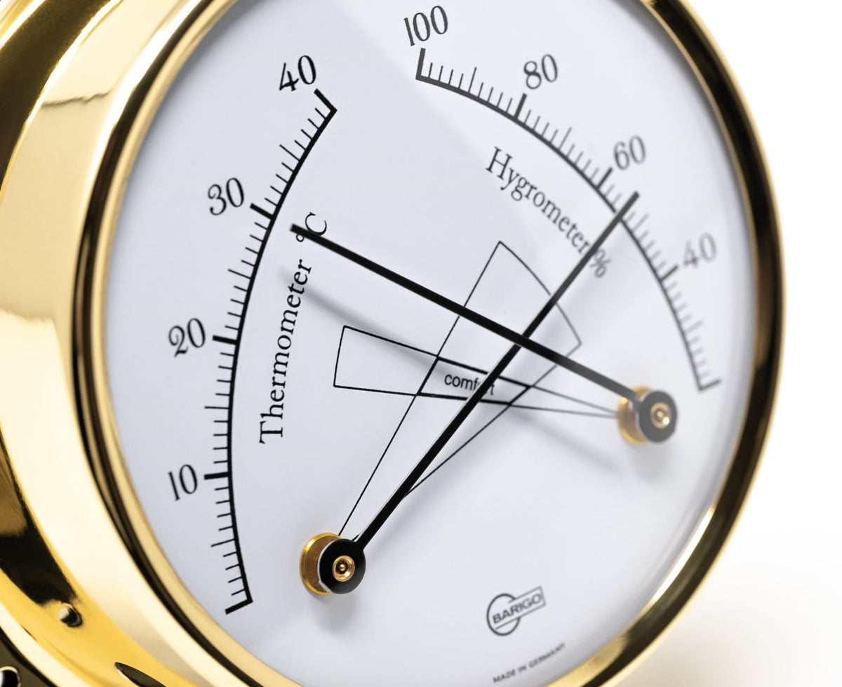 Gold analog hygrometer and thermometer weather instrument close-up