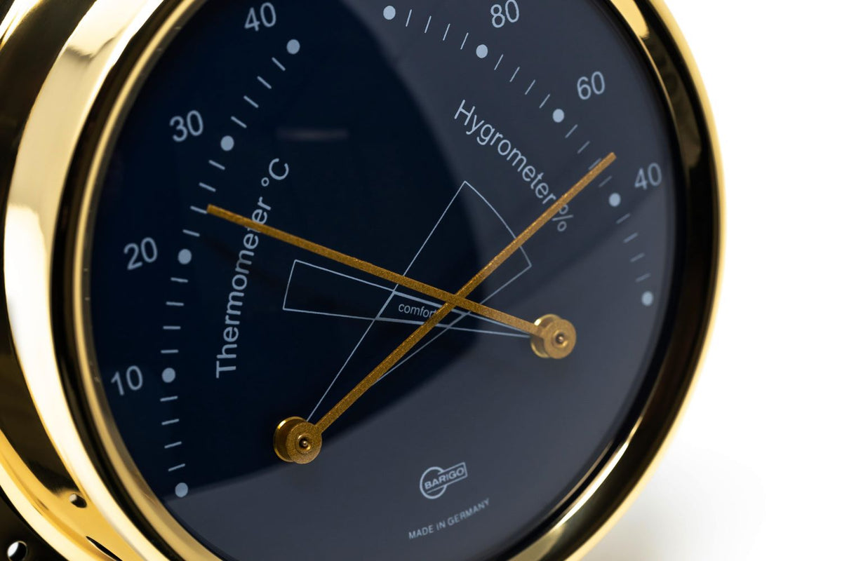 Close-up of a gold German analog thermometer hygrometer for indoor climate monitoring