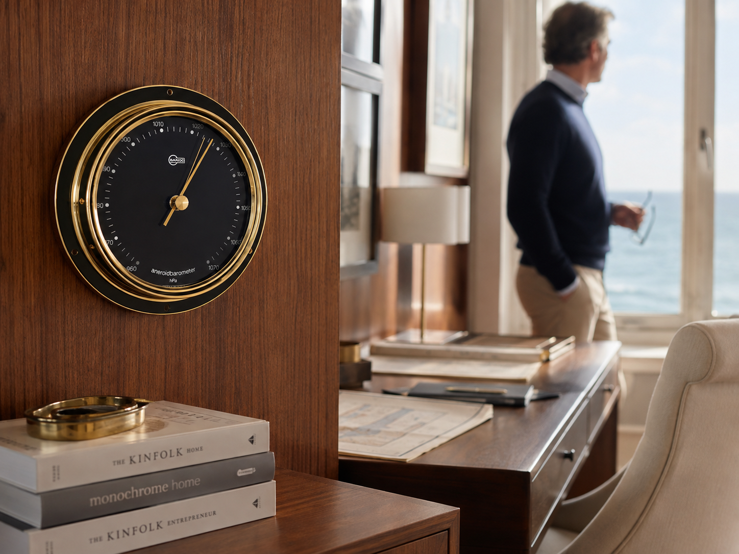 Gold-rimmed German aneroid barometer with black dial, pressure scale in hPa